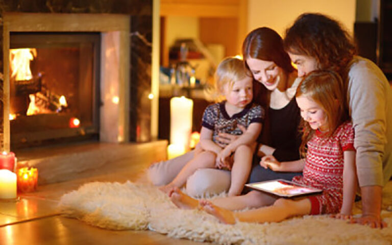 parent and children sitting near fireplace
