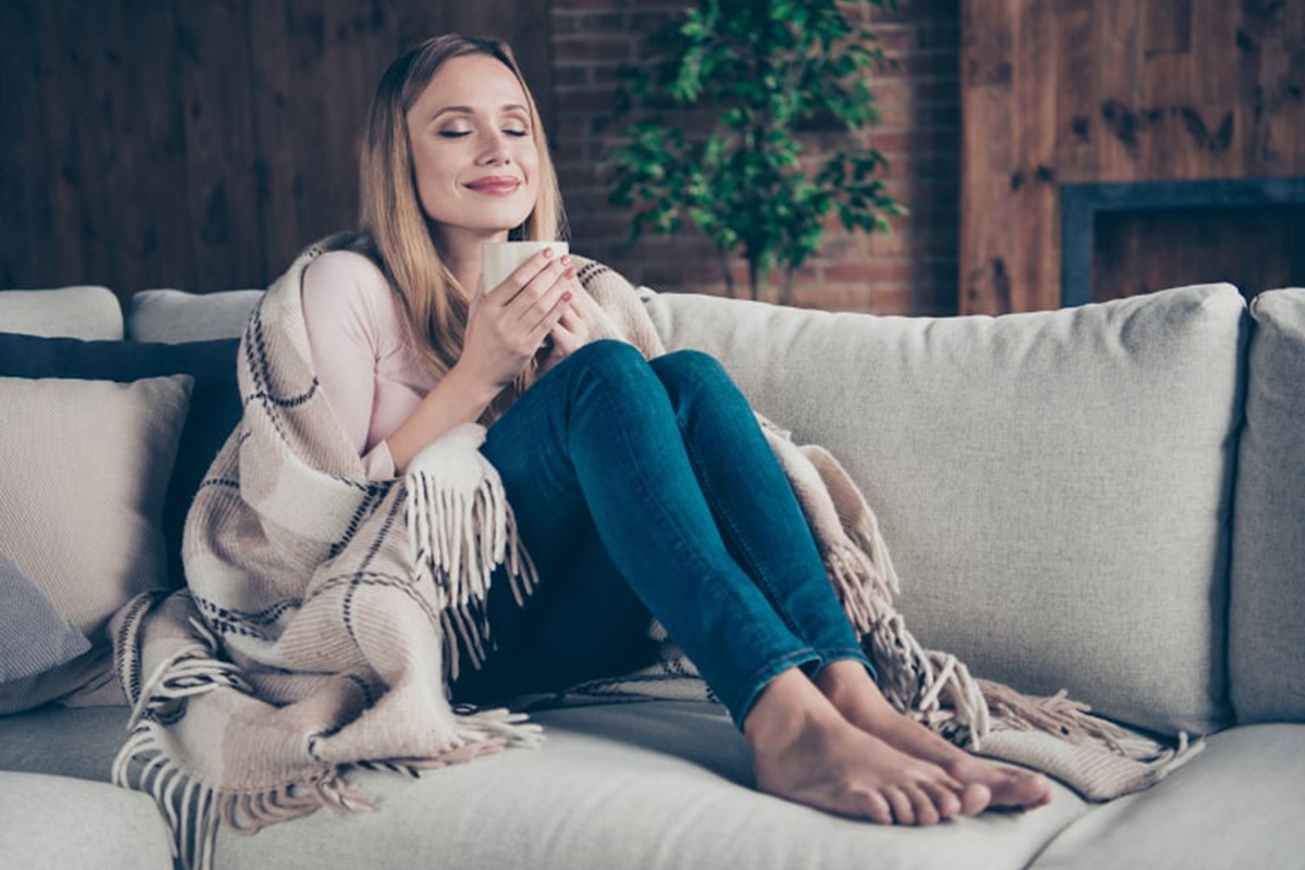 Woman in blanket on couch